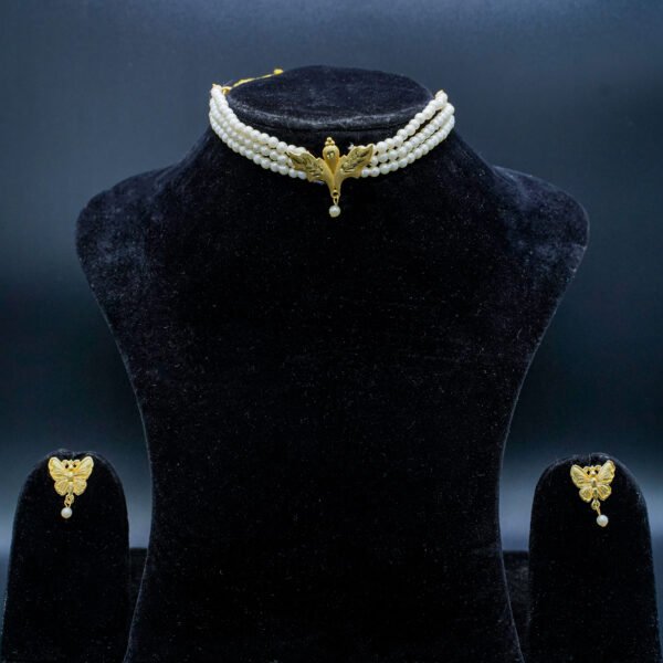 gold-tone chain necklace with a crystal butterfly pendant acting as the center element, which connects to a vertical chain drop